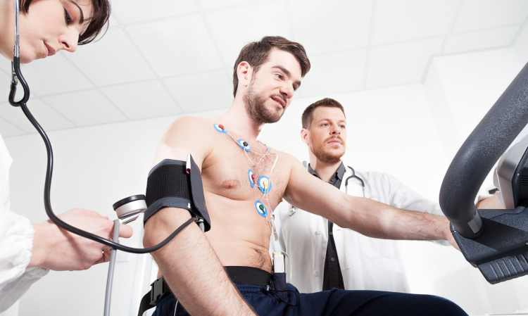 Serce sportowca - lekarze przygotowujący młodego mężczyznę do badania wysiłkowego serca